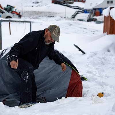 Rough sleeper Anders Maqe exits his tent surrounded by snow in Nuuk, Greenland, on March 6, 2025. Greenland, an autonomous Danish territory coveted by US President Trump and which votes on March 11, 2025 in legislative elections, is home to around 500 homeless people, or almost one percent of its population, according to a 2022 tally. The island's rapid modernisation and urbanisation over the past few decades is to blame. Since 1980 the population in Nuuk has doubled to 19,000 inhabitants, and the town aims to grow to 30,000 by 2030. Peppered with construction cranes, it now has a golf course, and as of last autumn, an international airport. And 150 homeless people. (Photo by Odd ANDERSEN / AFP)