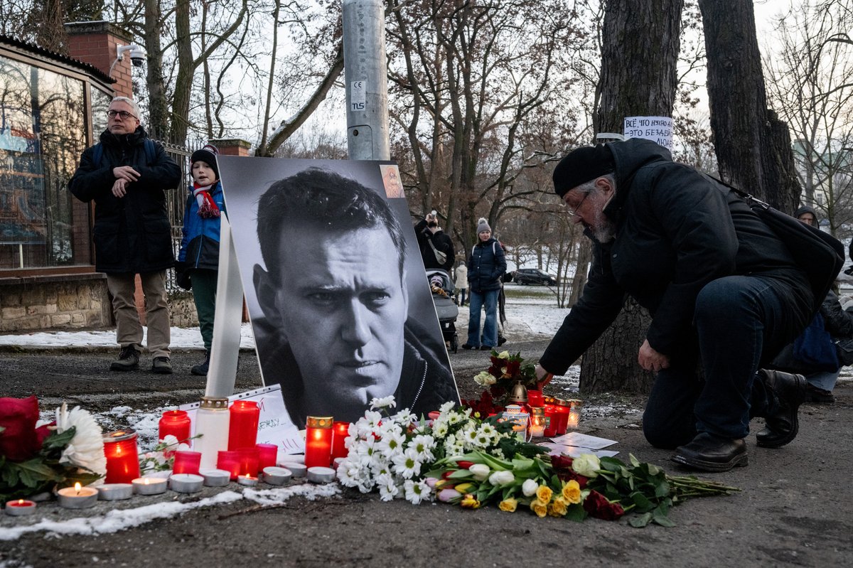 A mourner lays flowers at a makeshift memorial for late Russian opposition leader Alexei Navalny, marking the first anniversary of his death while incarcerated in a remote Arctic penal colony, in front of the Russian embassy in Prague, on February 16, 2025. (Photo by Michal Cizek / AFP) / NAVALNY HAS BEEN DECLARED "EXTREMIST" BY RUSSIAN AUTHORITIES. IN RUSSIA, ANYBODY WHO MENTIONS NAVALNY OR HIS ANTI-CORRUPTION FOUNDATION WITHOUT STATING THAT THEY HAVE BEEN DECLARED "EXTREMIST" IS SUBJECT TO FINES OR UP TO FOUR YEARS IN PRISON FOR REPEATED OFFENCES.