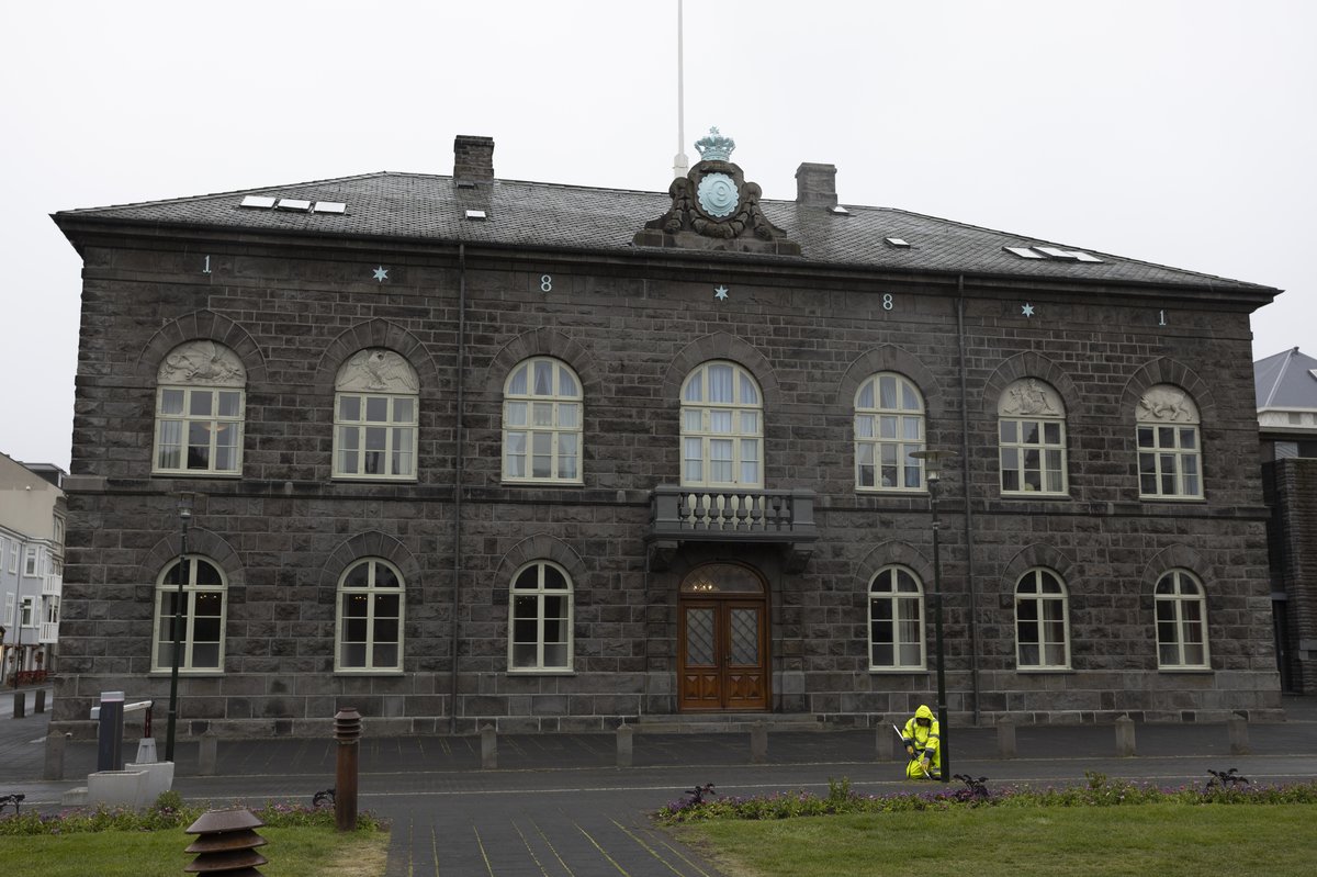 Starfsmaður Reykjavíkurborgar vinnur í beði fyrir framan Alþingishúsið